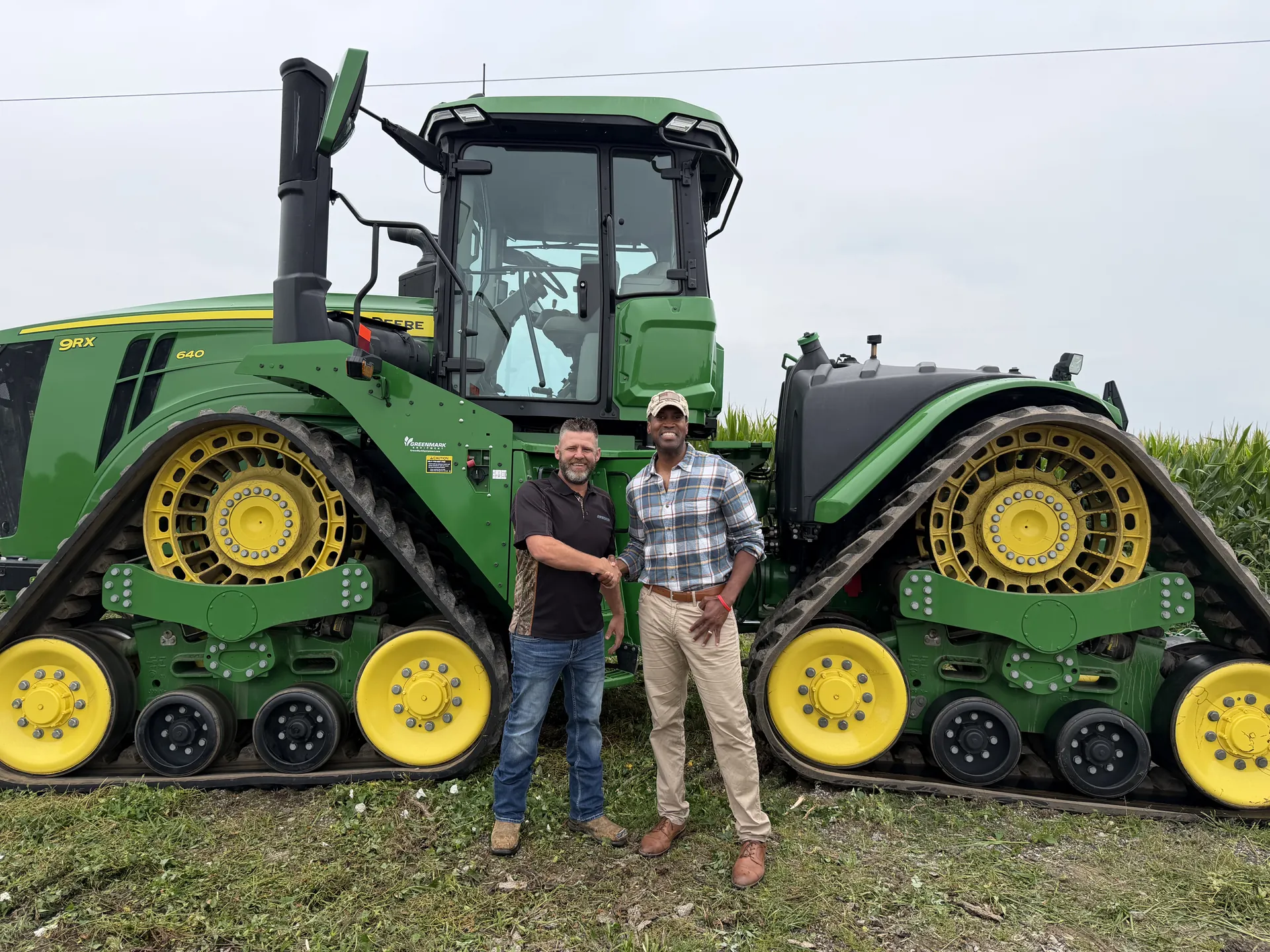 John James with a Michigan farmer in front of a tractor